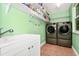 Efficient laundry room featuring a sink, shelving, and front-loading washer and dryer for convenience at 275 W 3Rd St, Chuluota, FL 32766