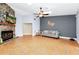 Cozy living room featuring a stone fireplace, tile floors, neutral paint, and bright skylights at 275 W 3Rd St, Chuluota, FL 32766