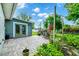 Paver patio with an outdoor dining set, grill and lush landscaping at 275 W 3Rd St, Chuluota, FL 32766