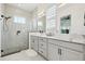 Modern bathroom featuring dual sinks, white cabinets, a glass-enclosed shower, and stylish fixtures at 2905 Tupelo Loop, St Cloud, FL 34772
