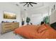 Bright bedroom featuring an orange quilt bedding set, TV, tile floors, and a ceiling fan at 2905 Tupelo Loop, St Cloud, FL 34772