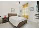 Comfortable bedroom with a queen size bed, side tables, and a large window with yellow curtains at 2905 Tupelo Loop, St Cloud, FL 34772