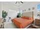 Bright primary bedroom featuring an orange quilt bedding set, tile floors, and natural light at 2905 Tupelo Loop, St Cloud, FL 34772