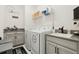 Well-organized laundry room with modern appliances, storage cabinets, and decorative wall art at 2905 Tupelo Loop, St Cloud, FL 34772
