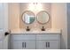 Bathroom featuring double sink with black hardware and round mirrors at 3042 Herold Dr, Orlando, FL 32805