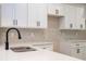 Well-appointed kitchen boasts white cabinets, stainless steel sink and modern fixtures and hardware at 3042 Herold Dr, Orlando, FL 32805