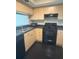 A kitchen featuring light wood cabinets, a black stove, and a stainless steel sink at 322 E Central Blvd # 908, Orlando, FL 32801