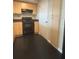 A kitchen features light wood cabinets, black appliances, and durable black flooring at 322 E Central Blvd # 908, Orlando, FL 32801
