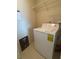 A laundry room is equipped with a white washing machine and shelving at 322 E Central Blvd # 908, Orlando, FL 32801