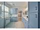 Bright bathroom featuring double vanity, walk-in shower and lots of storage with light-blue shaker cabinets at 3281 Saloman Ln, Clermont, FL 34711