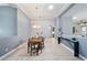 Bright dining room boasts wood table with seating for six beneath a decorative chandelier and ample natural light at 3281 Saloman Ln, Clermont, FL 34711