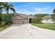 Charming single-story home featuring a three-car garage, manicured lawn, and a welcoming entryway at 3281 Saloman Ln, Clermont, FL 34711