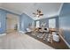 Open-concept living room with blue walls, modern decor, a geometric rug, and hardwood floors in hallway at 3281 Saloman Ln, Clermont, FL 34711