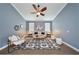 Cozy blue living room featuring modern decor, a geometric rug, and ample natural light from two windows at 3281 Saloman Ln, Clermont, FL 34711