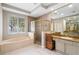 Elegant bathroom with a tub, a glass shower, and double sinks with granite countertops at 3317 Oakmont Ter, Longwood, FL 32779