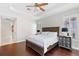 Comfortable bedroom with hardwood floors, plantation shutters, and a decorative tray ceiling at 3317 Oakmont Ter, Longwood, FL 32779