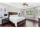 Bright bedroom with a tray ceiling, hardwood floors, and plantation shutters on the windows at 3317 Oakmont Ter, Longwood, FL 32779