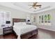 Bright bedroom with a tray ceiling, hardwood floors, and plantation shutters on the windows at 3317 Oakmont Ter, Longwood, FL 32779