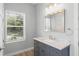 Bathroom featuring a gray vanity with marble countertop with window bringing in natural light at 34 Jackson Cir, Winter Springs, FL 32708