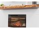 Modern electric fireplace with stone hearth and a decorative wood shelf at 34 Jackson Cir, Winter Springs, FL 32708