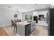 Bright kitchen with stainless steel appliances and an island with a sink and marble countertops and a dining table at 34 Jackson Cir, Winter Springs, FL 32708