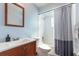 Light blue bathroom featuring a shower-tub combo with white tile surround and a wood vanity at 3511 E Crystal Lake Ave, Orlando, FL 32806