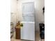 A stacked washer and dryer in a laundry area with tile flooring, white walls and an adjacent basket at 3511 E Crystal Lake Ave, Orlando, FL 32806