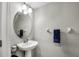 Powder room featuring a pedestal sink, oval mirror, and modern fixtures at 3661 Brighton Park Cir, Orlando, FL 32812