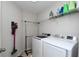 Laundry room with front load washer and dryer, overhead shelving, and neutral finishes at 3661 Brighton Park Cir, Orlando, FL 32812