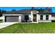 Charming single-story home featuring a gray garage door, stone accents, and a welcoming front yard at 4634 Sw 170Th Road, Ocala, FL 34473