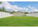 Large backyard with ample green space and a white privacy fence, offering a secure area for Gathering fun at 5345 Sunrise Blvd, Orlando, FL 32803
