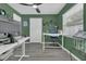 Green home office with standing desk, gray floors, ceiling fan, and large windows letting in natural light at 5345 Sunrise Blvd, Orlando, FL 32803