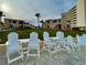 Exterior view with white adirondack chairs overlooking lush green grass at 573 N Atlantic Ave # 5, New Smyrna Beach, FL 32169