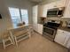 Efficient kitchen features stainless steel appliances, bright white cabinets, and a cozy breakfast nook at 573 N Atlantic Ave # 5, New Smyrna Beach, FL 32169