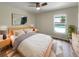 Comfortable bedroom with a ceiling fan, natural light, and views of the refreshing pool outside at 6740 Se 107Th St, Belleview, FL 34420