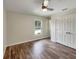 Bright bedroom featuring ceiling fan, closet, wood floors, and window overlooking the pool at 6740 Se 107Th St, Belleview, FL 34420