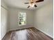 Bright bedroom with ceiling fan, closet, wood floors, and window with view to the backyard at 6740 Se 107Th St, Belleview, FL 34420