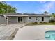 Back exterior featuring gray paint, white trim, patio, and a swimming pool at 6740 Se 107Th St, Belleview, FL 34420