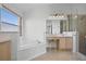 Bright bathroom featuring double sinks, vanity area, separate shower, and tub under a picture window at 7606 Fordham Creek Ln, Orlando, FL 32818