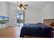 Bright bedroom with wood floors, ceiling fan, and sliding glass doors to the pool area at 7606 Fordham Creek Ln, Orlando, FL 32818