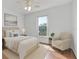 Cozy bedroom with a neutral color palette, natural light, and comfortable seating at 7606 Fordham Creek Ln, Orlando, FL 32818