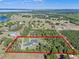 Aerial view of a large, modern home with large property outlined in red, surrounded by trees and a lake view in the distance at 8003 Lake Nellie Rd, Clermont, FL 34714