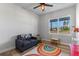 Bright bedroom with hardwood floors, a large window with a view, and a sofa with rocking chair and play table at 8003 Lake Nellie Rd, Clermont, FL 34714