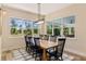 Bright dining room features a wood table, black chairs, and large windows with views of the outdoors at 8003 Lake Nellie Rd, Clermont, FL 34714