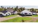 Stunning modern farmhouse featuring a black roof, red doors, green lawn and long driveway at 8003 Lake Nellie Rd, Clermont, FL 34714