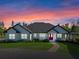 Stunning home featuring a modern design, lush landscaping, and striking red front door at 8003 Lake Nellie Rd, Clermont, FL 34714