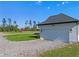 This property features a detached garage with a clean white door and sleek black sconces at 8003 Lake Nellie Rd, Clermont, FL 34714