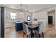 Modern kitchen with white cabinets, a blue island, and a dining area at 8003 Lake Nellie Rd, Clermont, FL 34714
