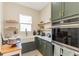 Modern kitchen features stainless steel appliances, olive green cabinetry, floating shelves, and a farmhouse sink at 8003 Lake Nellie Rd, Clermont, FL 34714