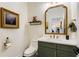 Stylish powder room with modern fixtures, decorative mirror and an eye-catching piece of art at 8003 Lake Nellie Rd, Clermont, FL 34714